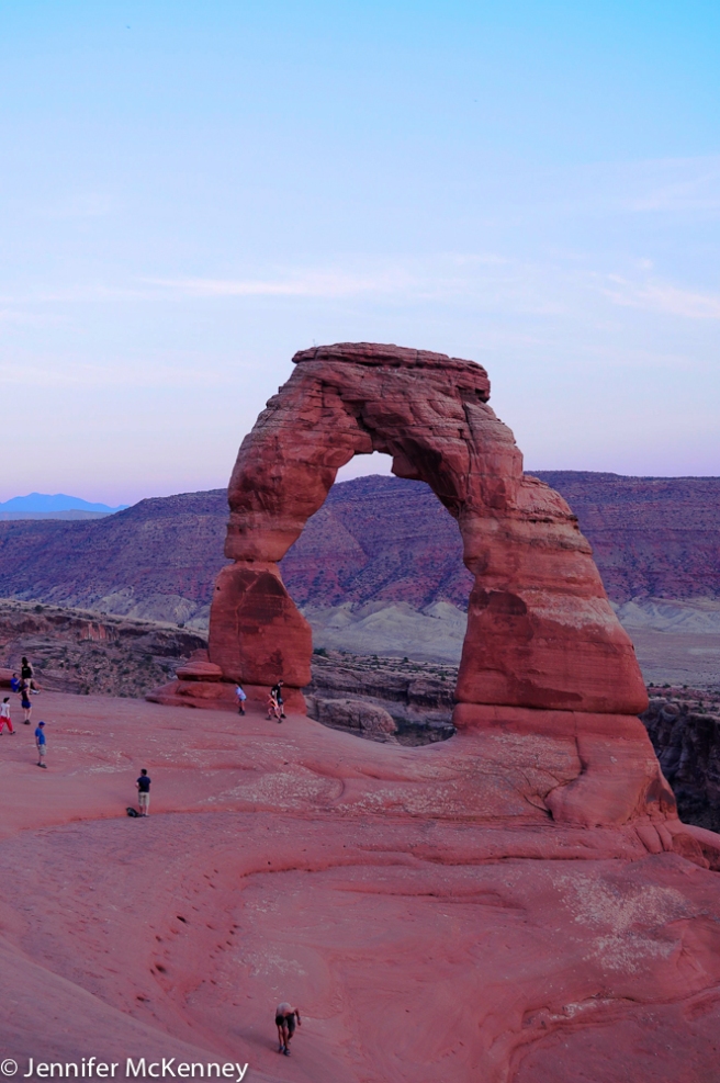 Moab, UT. Arches Nat'l Park. Tourists at Delicate Arch at Sunset. July 2014.